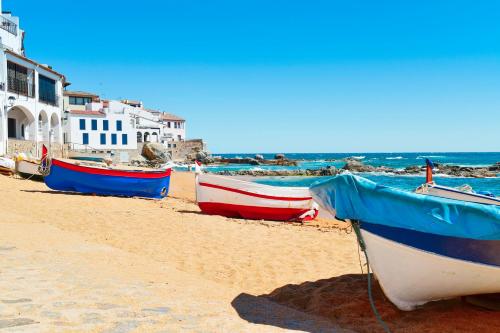 a group of boats sitting on the beach at Can Felip Apartments in Palafrugell