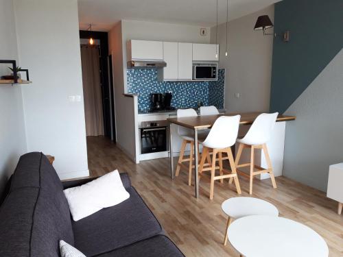 un salon avec un canapé, une table et des chaises dans l'établissement Appartandernos, à Andernos-les-Bains