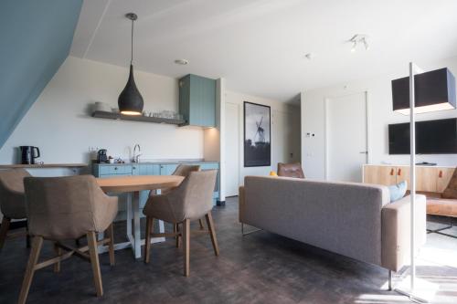 a kitchen and living room with a table and chairs at Hotel Kaap West I Kloeg Collection in Westkapelle