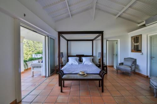 a bedroom with a canopy bed and a chair at Dream Villa Anse Marcel 546 in Anse Marcel 