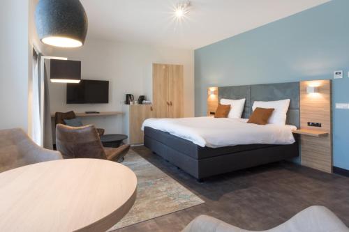 a hotel room with a bed and a table at Hotel Kaap West I Kloeg Collection in Westkapelle