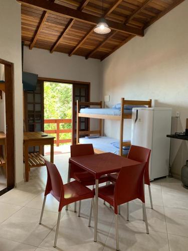 una habitación con una mesa y sillas y una litera en Flats Alto das Pedras, en Trindade