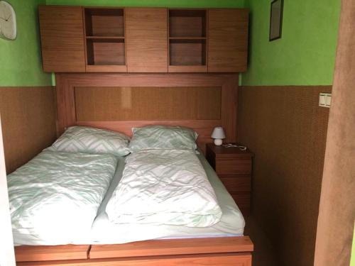 uma cama com uma cabeceira em madeira num quarto em Club 218 Panoráma Apartman em Siófok