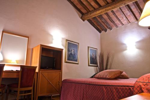 a bedroom with a bed and a desk and a television at Hotel La Luna in Lucca