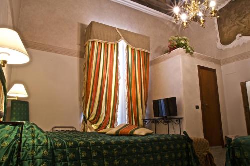 a bedroom with a green bed and a window at Hotel La Luna in Lucca
