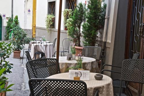 an outdoor patio with tables and chairs and plants at Hotel La Luna in Lucca