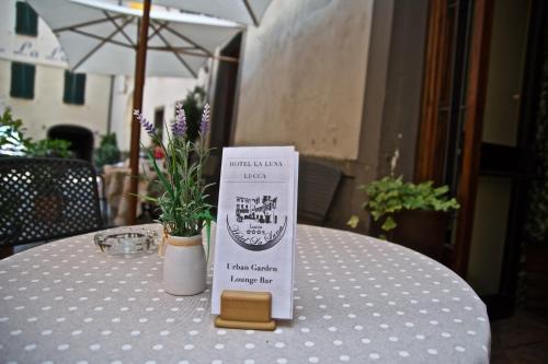 a table with a sign sitting on top of a table at Hotel La Luna in Lucca