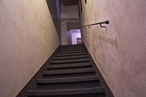 a staircase in a building with a railing on the wall at Hotel La Luna in Lucca