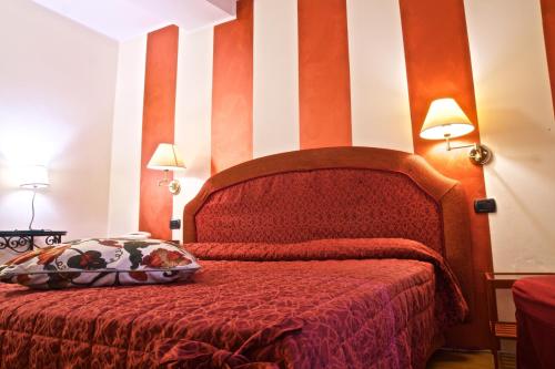 a bedroom with a red bed with striped walls at Hotel La Luna in Lucca