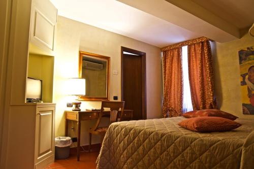 a hotel room with a bed and a desk and a window at Hotel La Luna in Lucca
