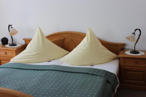 a bed with yellow pillows on it with two lamps at Villa Jagdhaus in Wernigerode