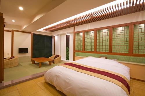 Hotel Bintang Pari Resort (Adult Only) في كوبه: غرفة نوم مع سرير وغرفة معيشة