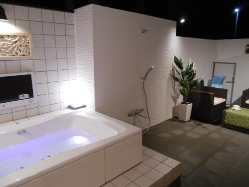 y baño con bañera blanca grande. en Hotel Regina, en Kashiwa