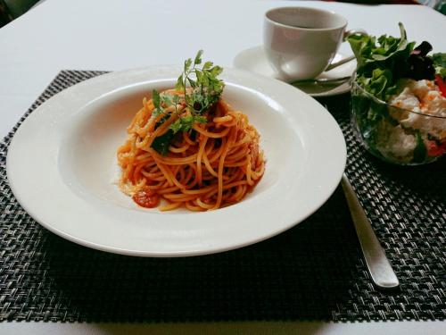 a white plate of spaghetti on a table at Hotel Regina in Kashiwa