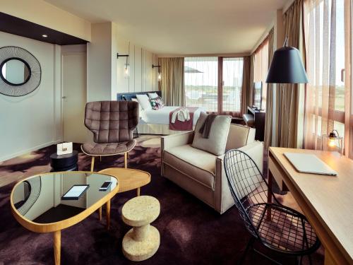 a living room with a couch and a table at Mercure Lyon Genas Eurexpo in Genas