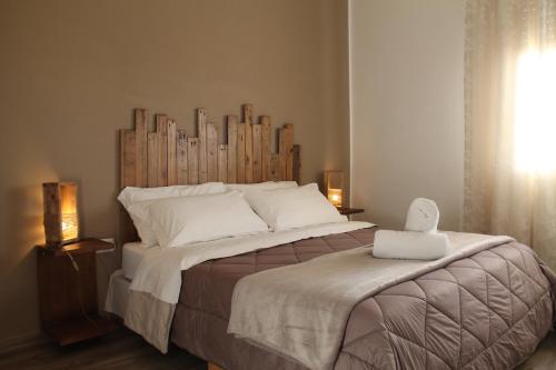 San PancrazioにあるB&B Gepparinoのベッドルーム1室(大型ベッド1台、木製ヘッドボード付)