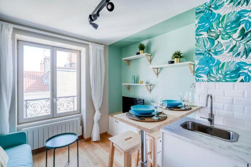 eine Küche mit einem Waschbecken und einem Fenster in der Unterkunft HONORÊ - Suite Carnot in Lyon