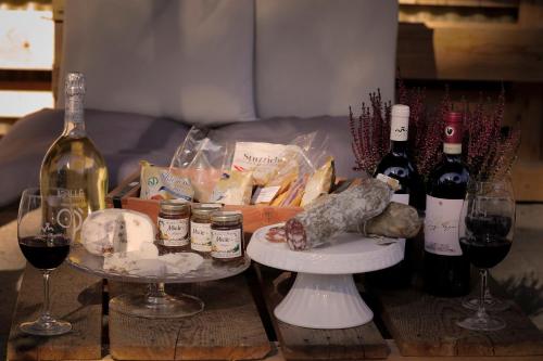 a table with two glasses of wine and wine bottles at AZ.AGR.POGGIO REGINI in Castellina in Chianti