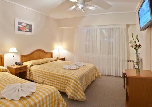 Cette chambre comprend deux lits et une télévision. dans l'établissement Garden Hotel, à Mar del Plata