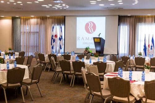 a conference room with tables and chairs and a podium at Ramada Jerusalem Hotel in Jerusalem