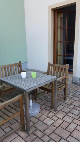 een picknicktafel en twee banken op een patio bij Gästezimmer Hille in Bad Schandau