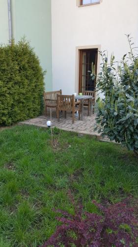 una panca di legno seduta su un patio in un cortile di Gästezimmer Hille a Bad Schandau