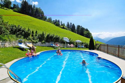 un grupo de personas sentadas en una piscina en Pension-Appartement Mitterhofer, en Scena