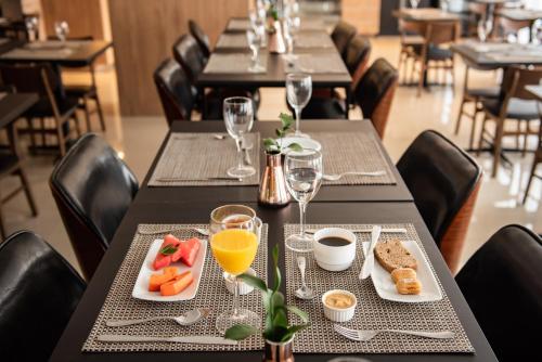 a table with plates of food and glasses of orange juice at Intercity Sao Leopoldo in São Leopoldo