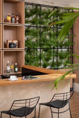 two black chairs sitting at a counter with a table at Intercity Sao Leopoldo in São Leopoldo