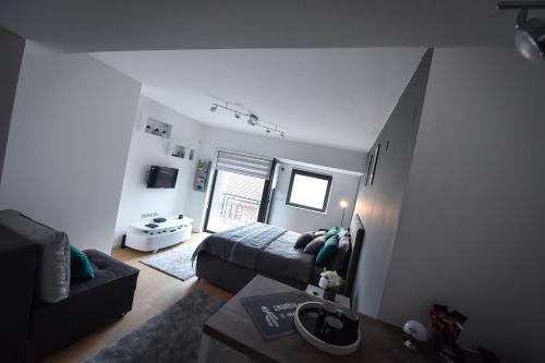 a living room with a bed and a couch at Urban Apartment in Niš