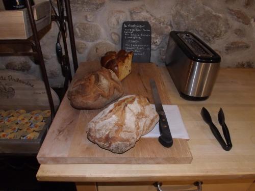 a cutting board with two loaves of bread and a knife at Hotel du Lac Foix in Foix