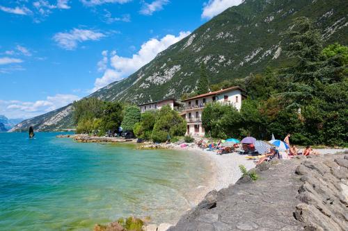 a group of people on a beach near the water at Albergo Campeggio Bommartini in Malcesine