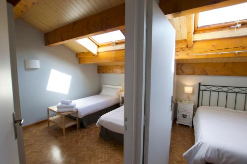 um quarto com 2 camas num quarto com tectos em madeira em Apartamento Els Vinyals em Estavar