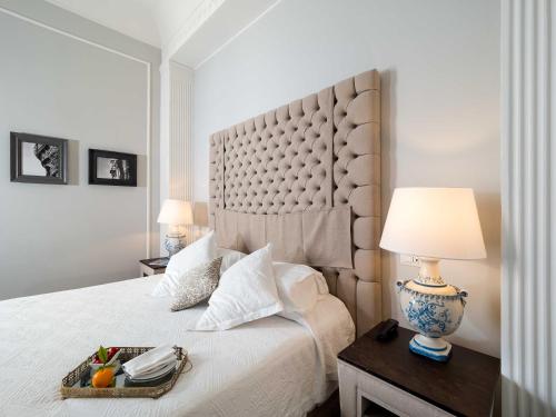 a bedroom with a large bed with a large headboard at Gagliardi Boutique Hotel in Noto