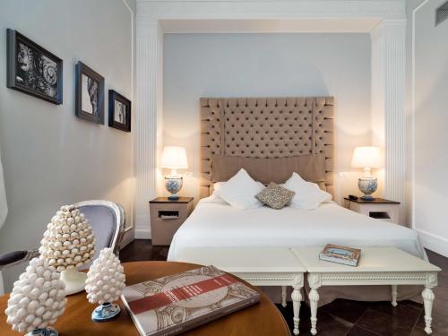 a bedroom with a white bed and a table with a table sidx sidx at Gagliardi Boutique Hotel in Noto
