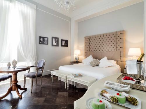 a hotel room with a bed and a table with food at Gagliardi Boutique Hotel in Noto