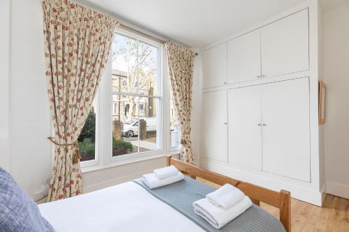 ロンドンにあるBright Clapham flat with private garden, sleeps 4のベッドルーム1室(ベッド1台、大きな窓付)