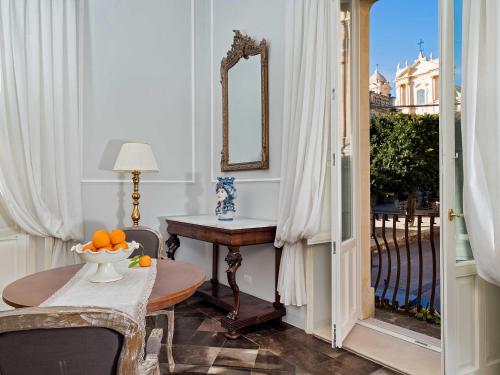 a dining room with a table and a mirror at Gagliardi Boutique Hotel in Noto