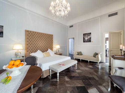 a hotel room with a bed and a table with oranges on it at Gagliardi Boutique Hotel in Noto