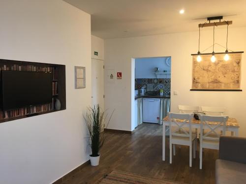 a living room with a dining room table and a television at Casa do Peso 1 in Peso da Régua