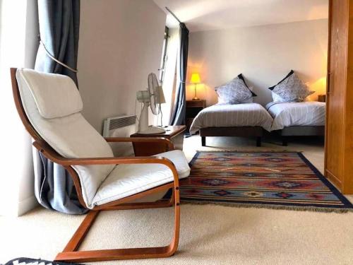 een kamer met 2 bedden, een stoel en een tapijt bij Le Penthouse Thorigny in Parijs