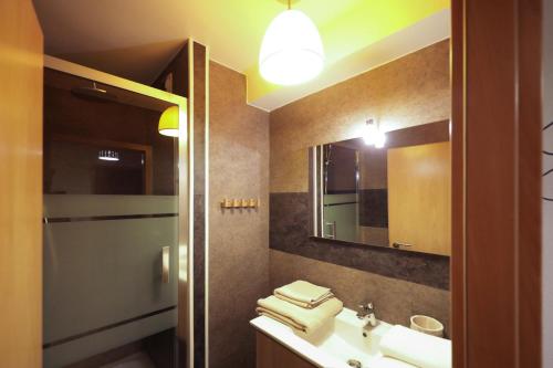 une salle de bain avec un lavabo et un miroir dans l'établissement Au buisson de roses, à Colmar