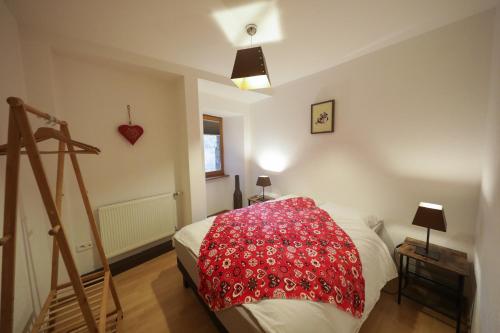 une chambre avec un lit avec une couverture rouge dessus dans l'établissement Au buisson de roses, à Colmar