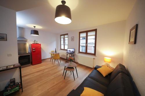 - un salon avec un canapé et un réfrigérateur rouge dans l'établissement Au buisson de roses, à Colmar