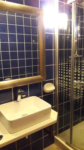 y baño con lavabo blanco y espejo. en Villa Pintar, en Povile