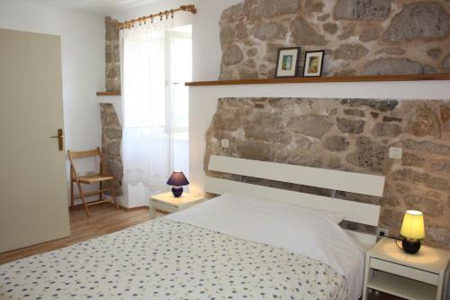 a bedroom with a bed and a stone wall at Apartment Nirvana in Vrsar