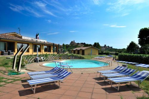 a group of lounge chairs next to a swimming pool at Le Macerine in Castiglione del Lago