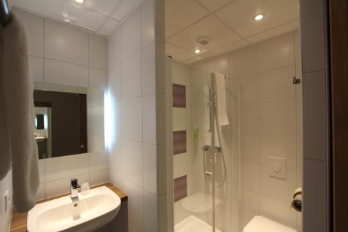 a white bathroom with a shower and a sink at ibis Styles Castres in Castres