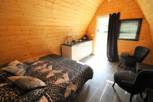 a bedroom with a leopard print bed in a log cabin at Luxe Eco Pod op Camping de Stal in Drijber