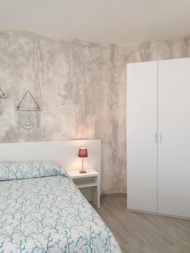 a bedroom with a bed and a white cabinet at Caletta sul Mare in La Caletta